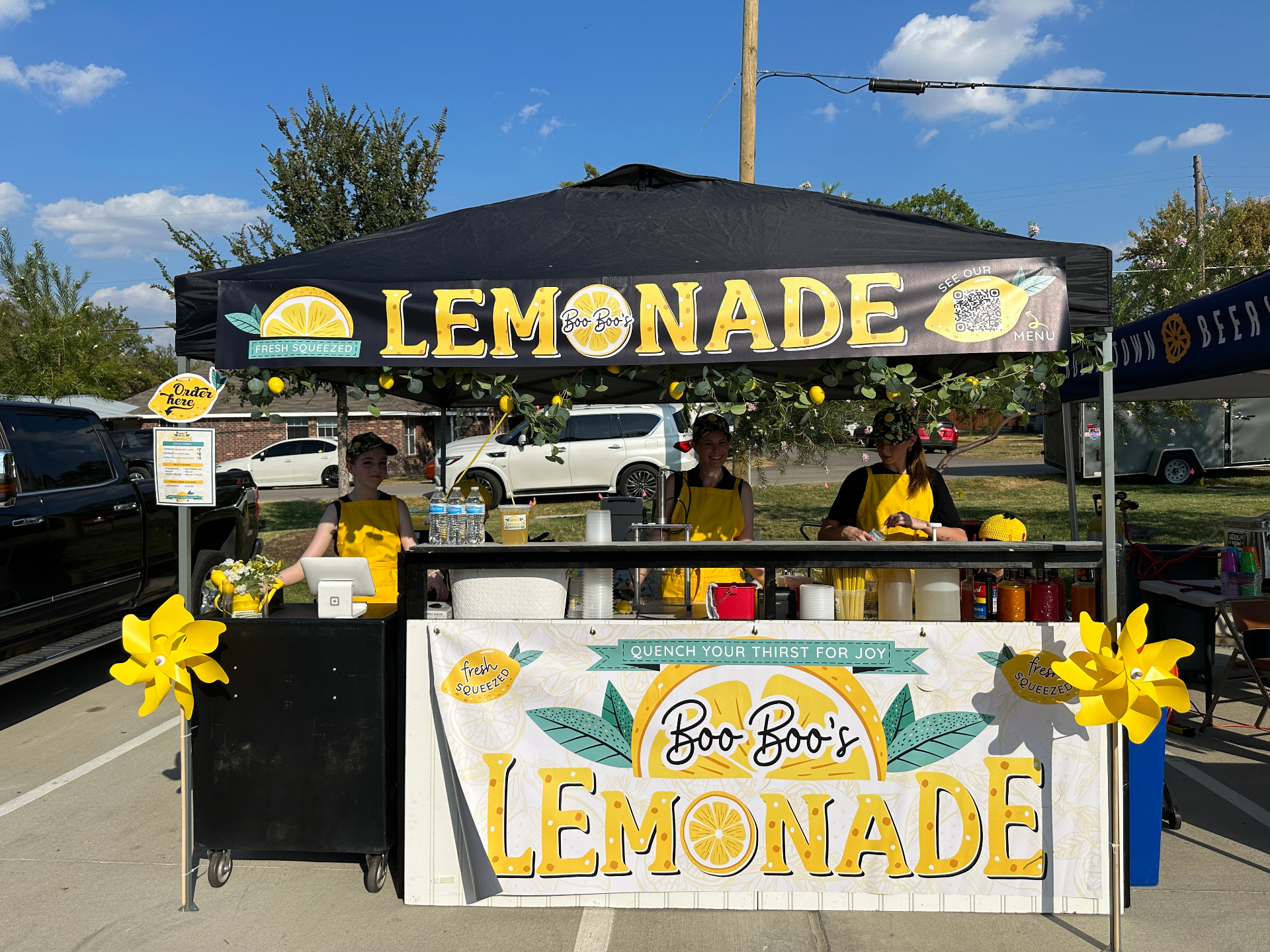 Team under canopy with pinwheels at outdoor market