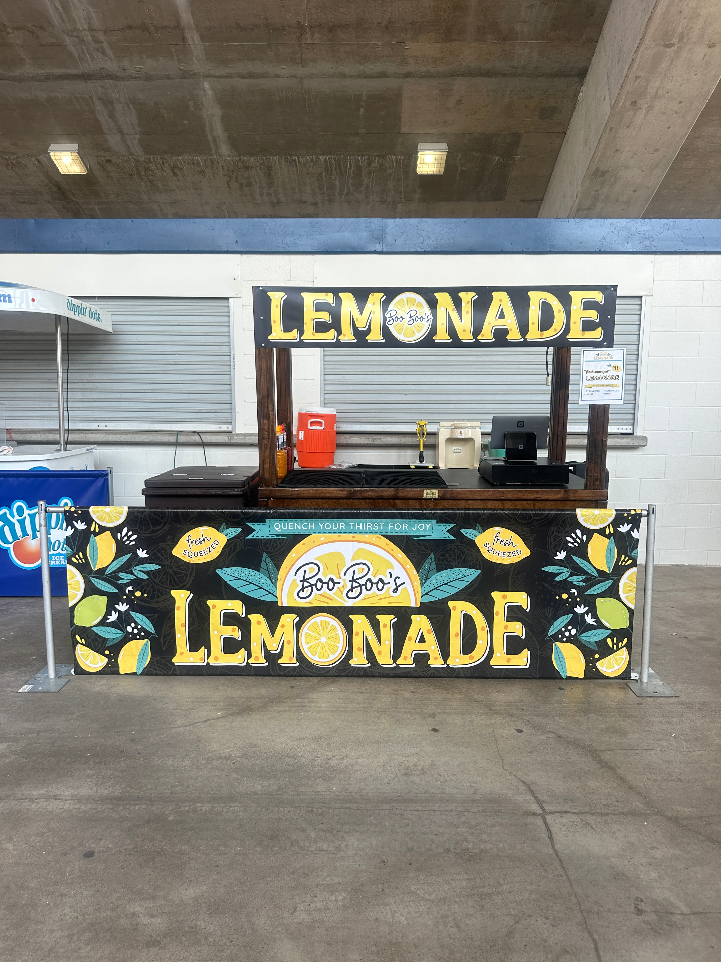 Branded lemonade stand at a stadium concourse
