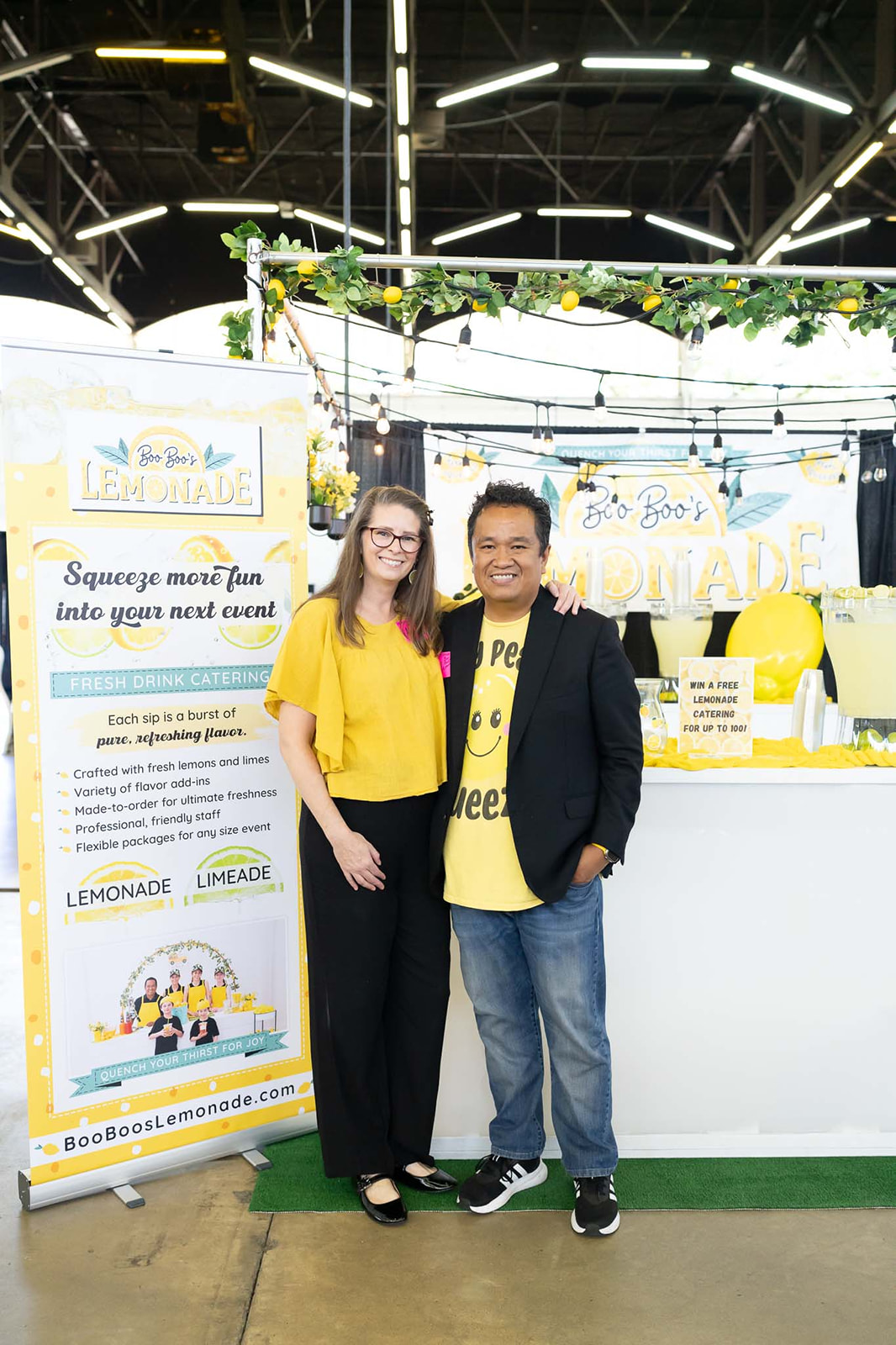 Owner pair standing at indoor expo booth