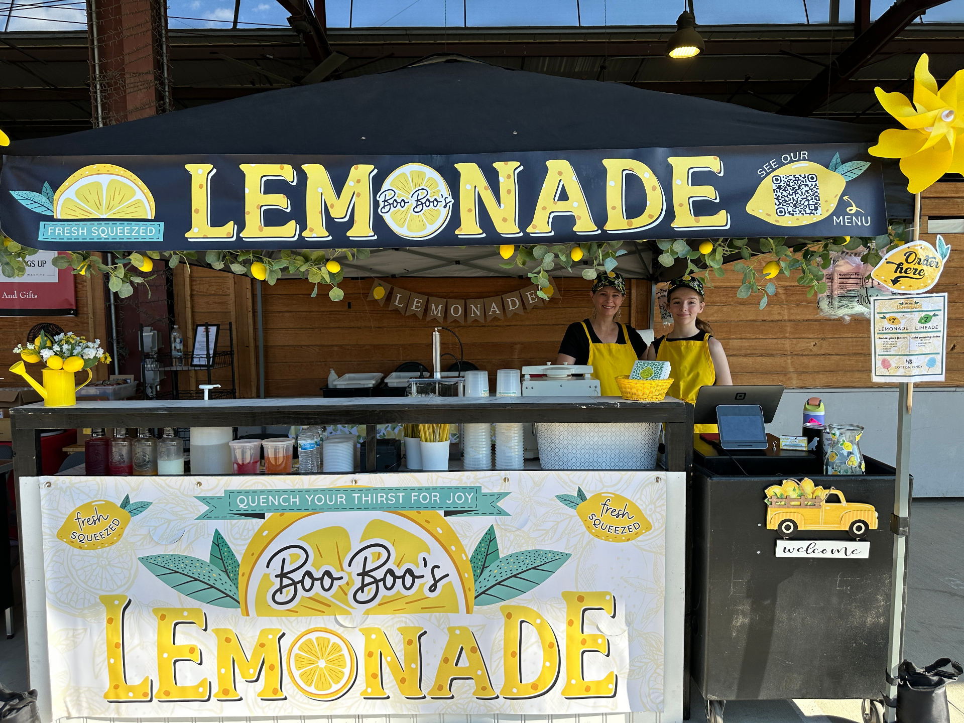 Market booth with banner and team ready to serve
