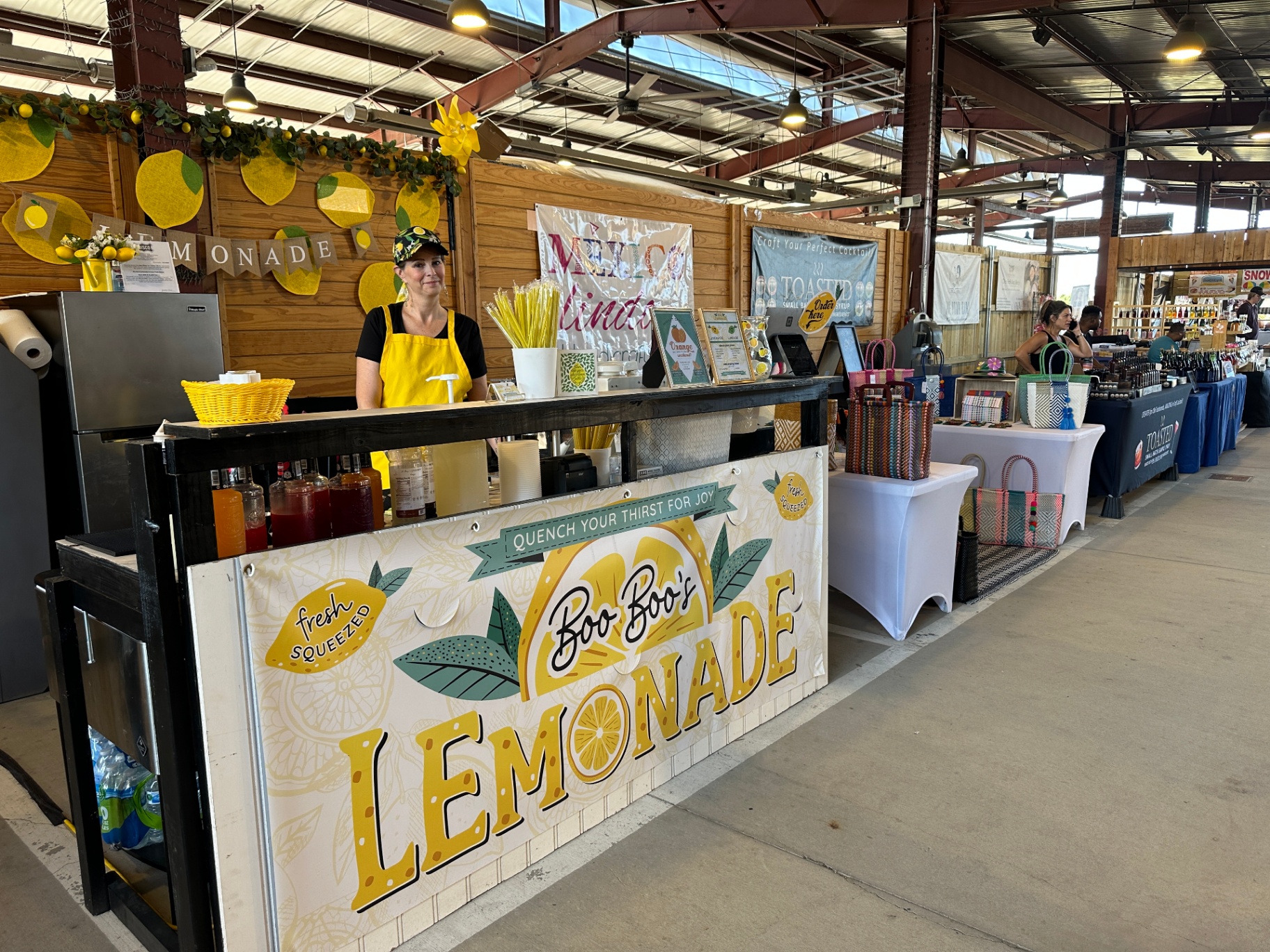 Indoor market row setup with Boo Boo's lemonade counter