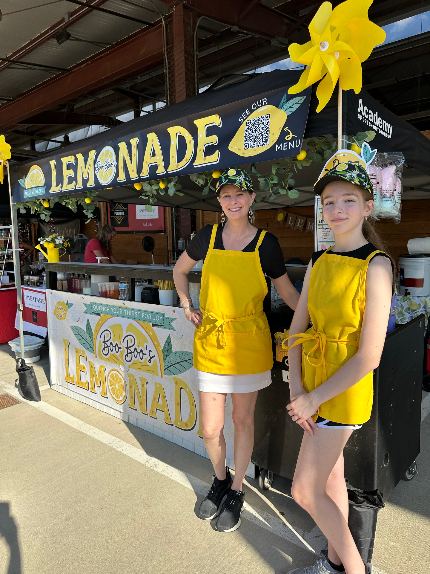 Mother and daughter team portrait at market booth