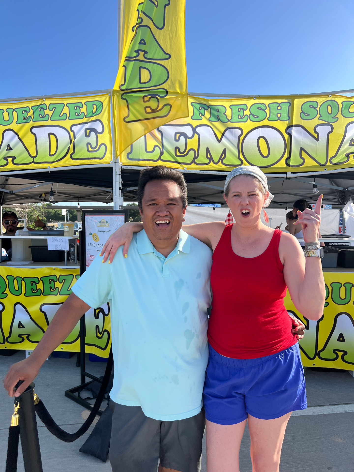 Close-up of owners in front of festival lemonade booth