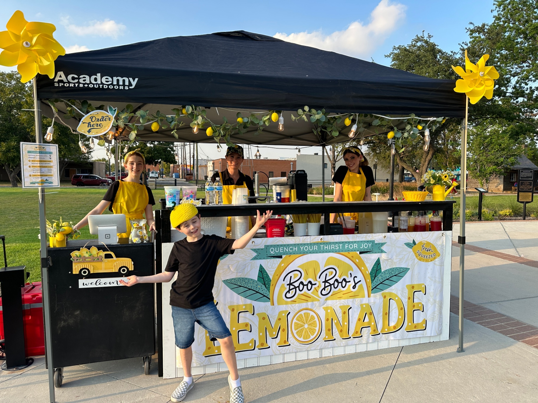 Family team at park lemonade setup with kid posing